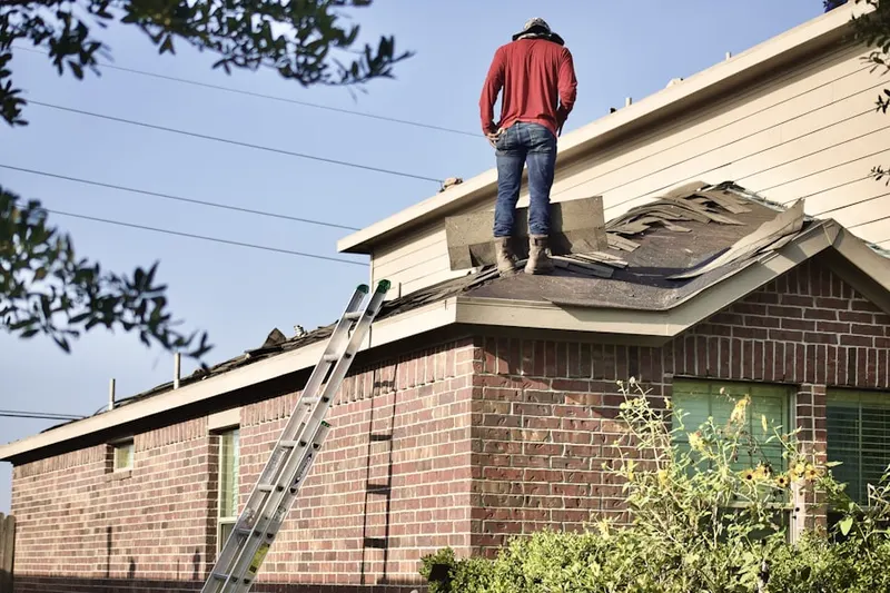 Professional roofer working on a residential roof in Manhatten